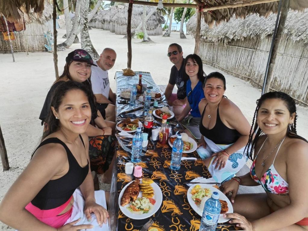 een groep mensen die rond een tafel zitten met eten bij Gunayar amazing in Arritupo Número Dos