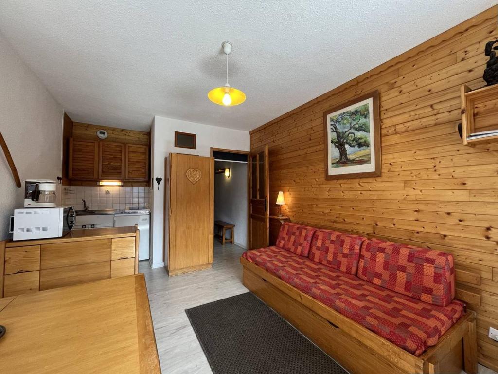 sala de estar con sofá rojo en la cocina en Appartement Peisey-Nancroix-Plan Peisey, 1 pièce, 4 personnes - FR-1-757-79, en Peisey-Nancroix