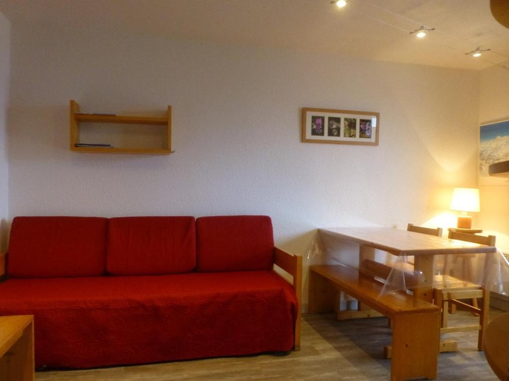 a living room with a red couch and a table at Appartement Peisey-Vallandry, 2 pièces, 5 personnes - FR-1-757-80 in Landry