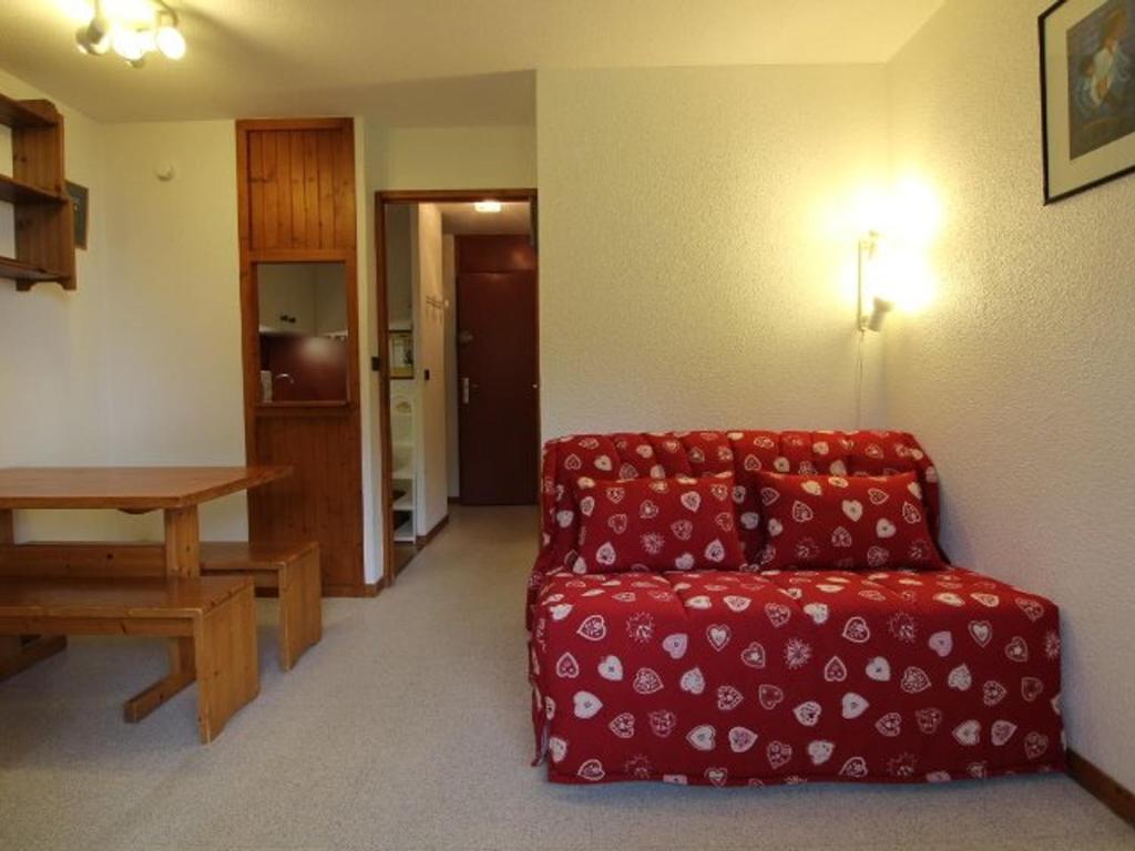 a living room with a red couch and a wooden table at Appartement Peisey-Vallandry, 1 pièce, 4 personnes - FR-1-757-82 in Landry