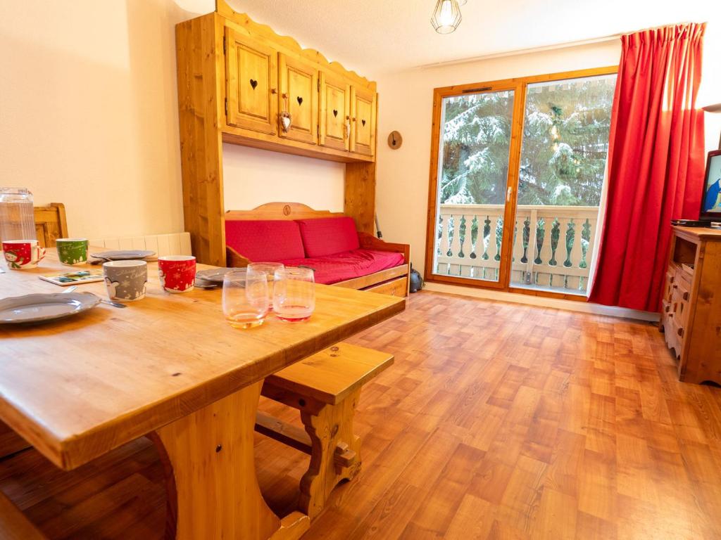 een woonkamer met een houten tafel en een rode bank bij Appartement Valfréjus, 3 pièces, 7 personnes - FR-1-468-118 in Modane