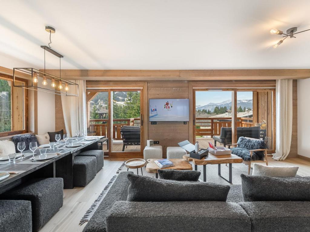 un salon avec des canapés et une télévision à écran plat dans l'établissement Luxueux Appartements au Pied du Mont d'Arbois, Megève, avec Espace Bien-Être et Salle de Cinéma - FR-1-569-106, à Megève