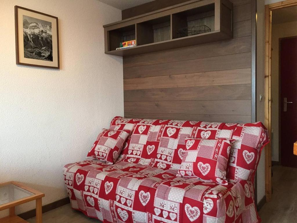 a bed with a red and white blanket in a room at Appartement Peisey-Vallandry, 2 pièces, 5 personnes - FR-1-757-86 in Landry