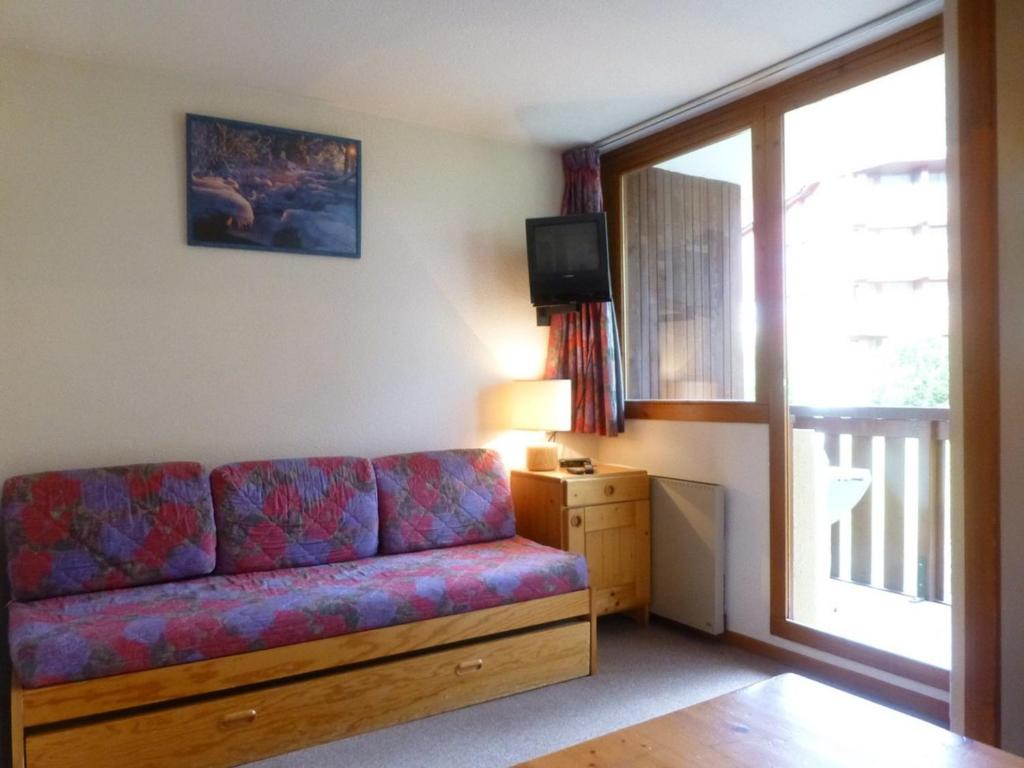 a living room with a couch and a television at Appartement Peisey-Vallandry, 1 pièce, 4 personnes - FR-1-757-88 in Landry