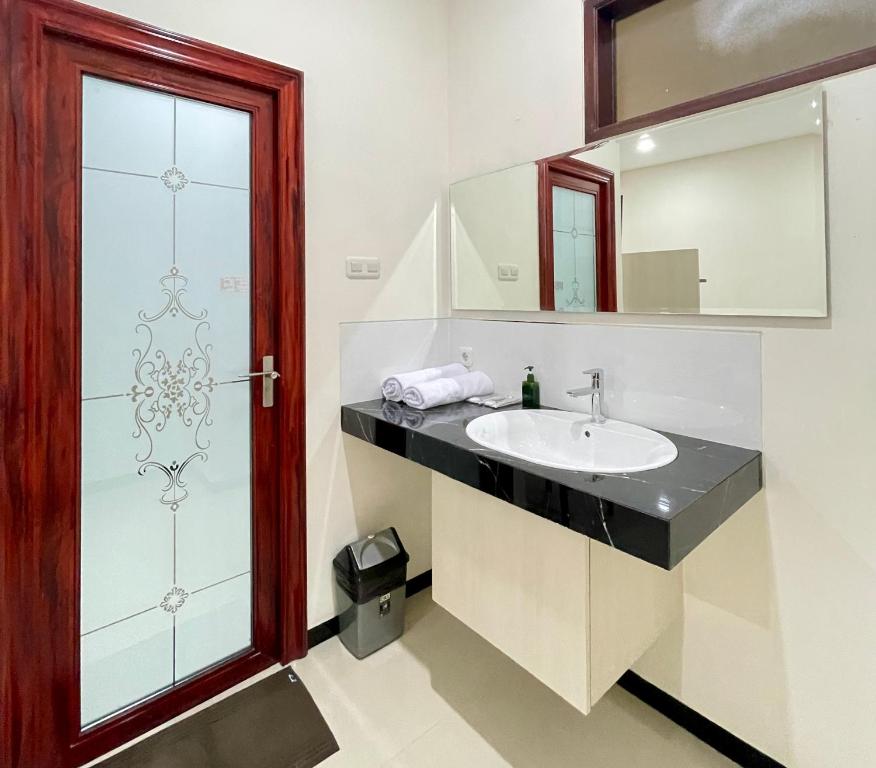 a bathroom with a sink and a mirror at Kawa Living in Krukah