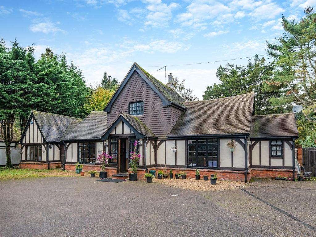 una casa grande con techo de gambrel en Gardeners Cottage, en Kelvedon Hatch