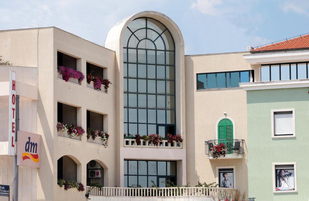 a building with windows and flower boxes on the balconies at Hotel Bellevue Trogir in Trogir