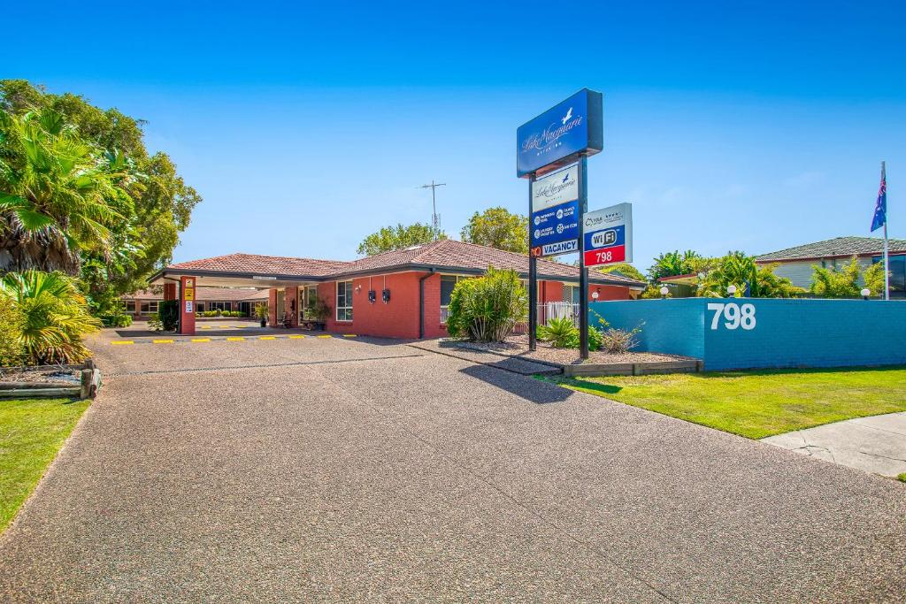 a gas station with a sign in front of it at Lake Macquarie Motor Inn in Belmont