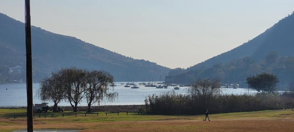 a person standing next to a lake with boats in it at Waterfront Guest House in Hartbeespoort