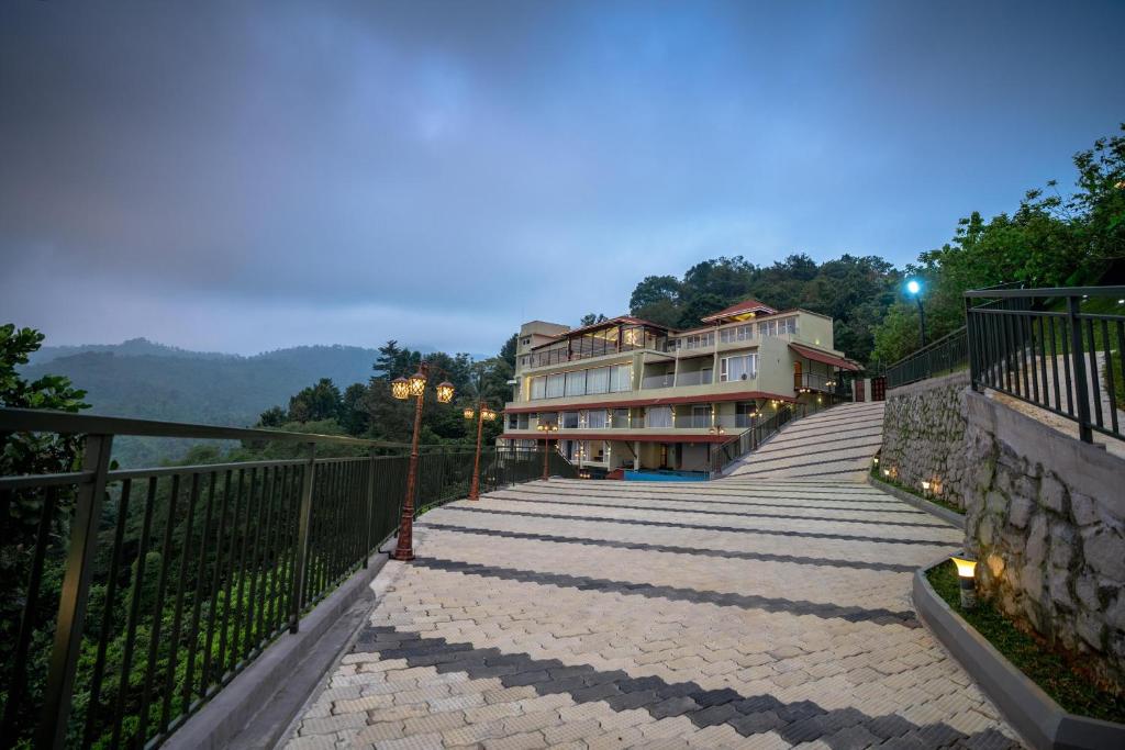 a building with a staircase leading up to a balcony at Misty Queen By Dimora Hotels in Kakkadampoyil
