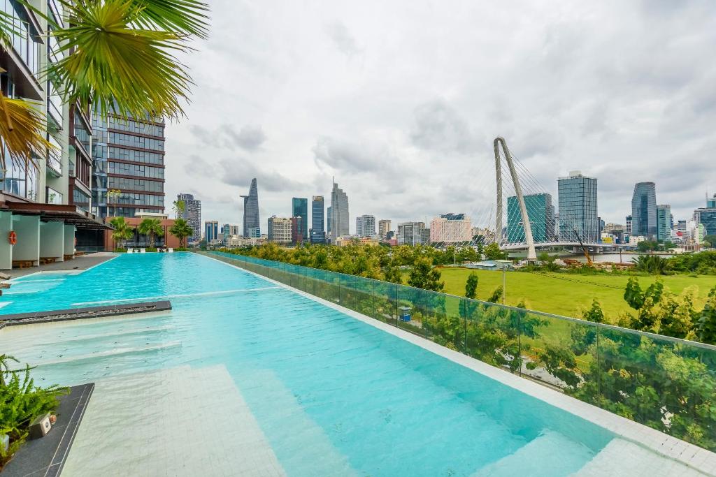 einen Pool mit einer Skyline der Stadt im Hintergrund in der Unterkunft Metropole Saigon Suites in Ho-Chi-Minh-Stadt