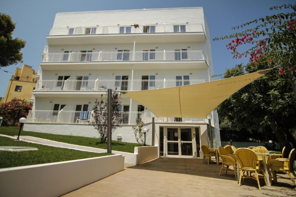 un gran edificio blanco con sillas y mesas delante de él en Hostel Floridita Adults Only, en Magaluf