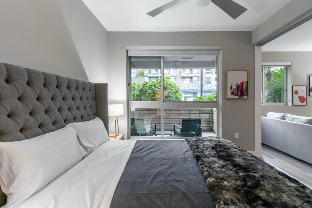 1 dormitorio con cama grande y ventana grande en Brand New WeHo Luxury Apartment, en Burbank