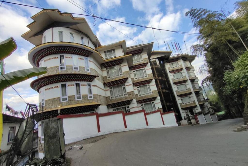 un edificio alto con una valla delante en Jain Group- Keepsa Residency & Spa, Gangtok en Gangtok
