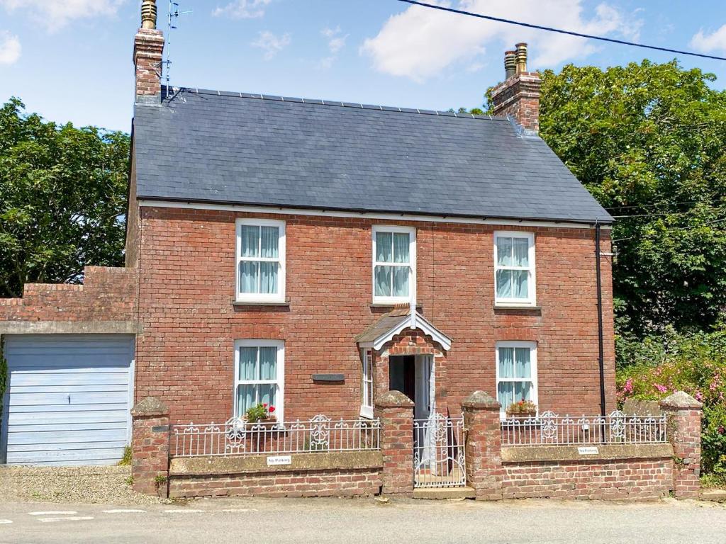 a red brick house with a gate and a garage at Manor Villa in Llanrian