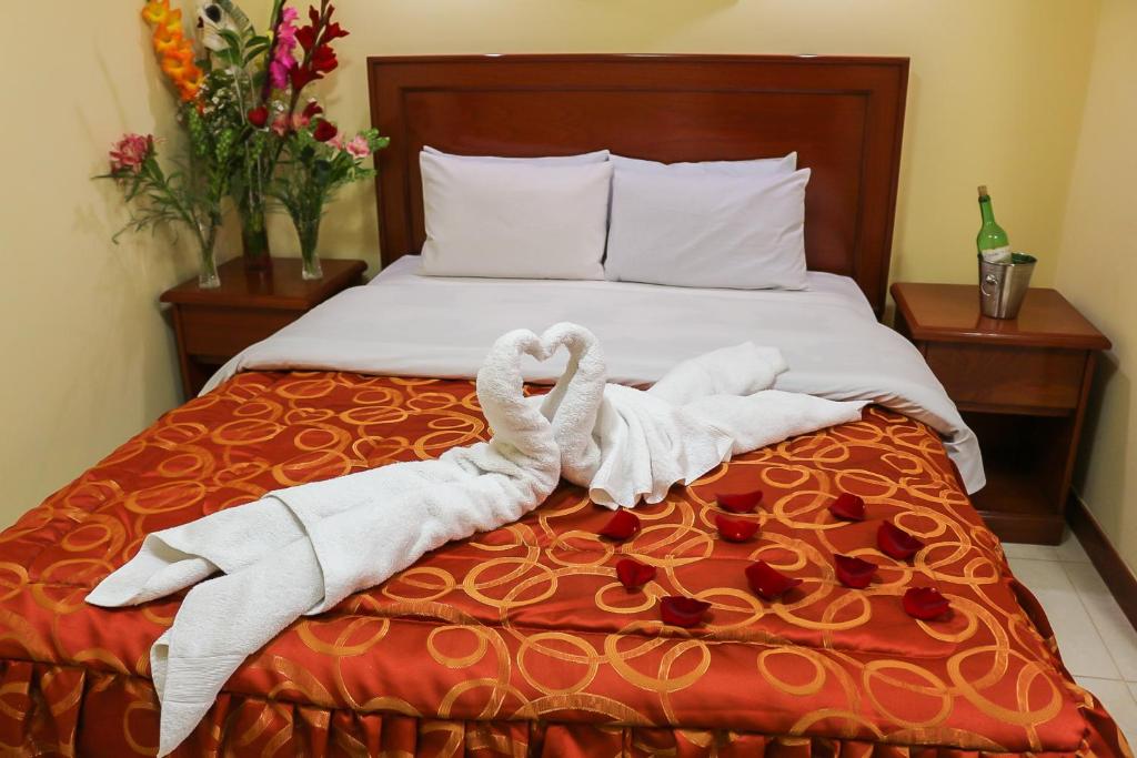 Dos toallas están hechas para parecer cisnes en una cama. en Hotel Elmer-Z, en Cusco