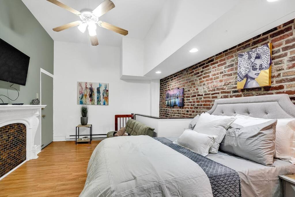 - une chambre avec un lit et un mur en briques dans l'établissement Uniquely Designed Metropolitan Apt In Center City, à Philadelphie