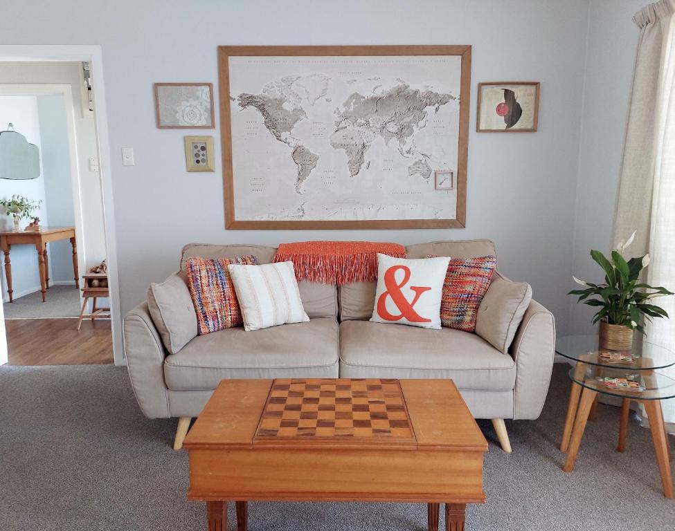 sala de estar con sofá y mesa de ajedrez en Cottage135-Rotorua, en Rotorua