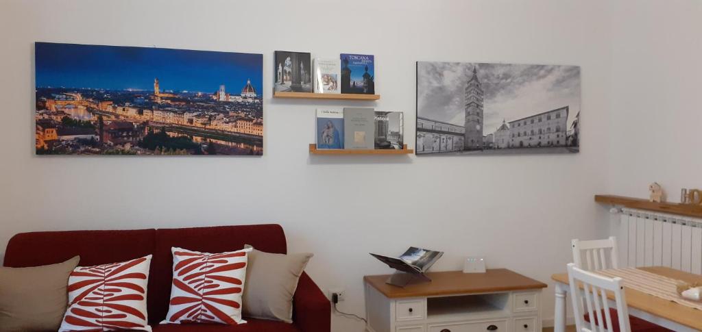 a living room with four pictures on the wall at Stella Apartment in Pistoia