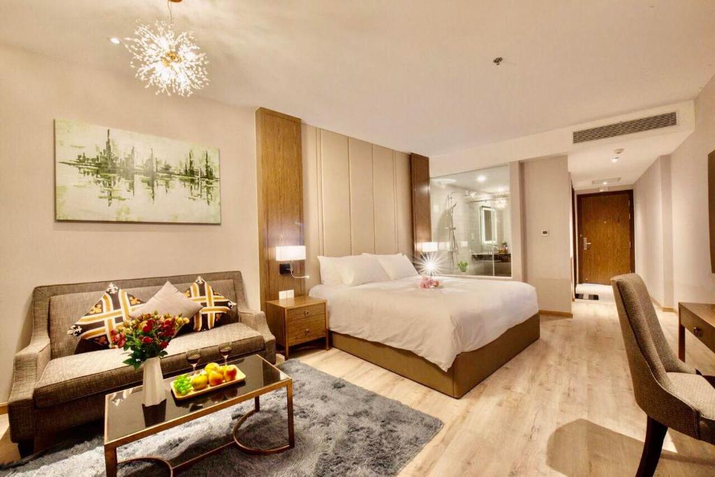 Habitación de hotel con cama y sofá en Panorama Central Square Apartment, en Nha Trang