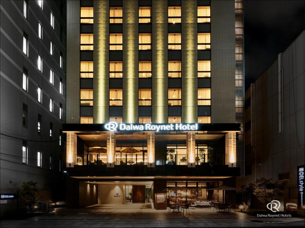 DEL style Osaka-Shinsaibashi by Daiwa Roynet Hotel في أوساكا: مبنى مع فندق downing house اضاءه بالليل