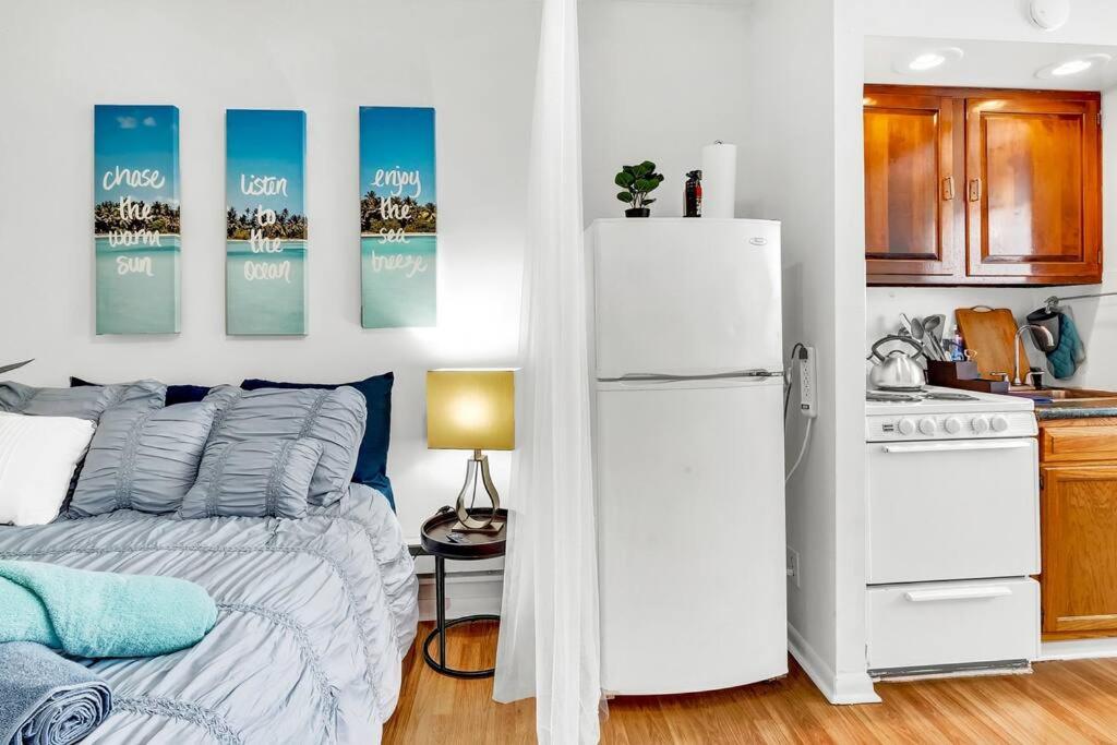 a bedroom with a bed and a white refrigerator at Private Remodeled Studio In Vibrant Center City in Philadelphia