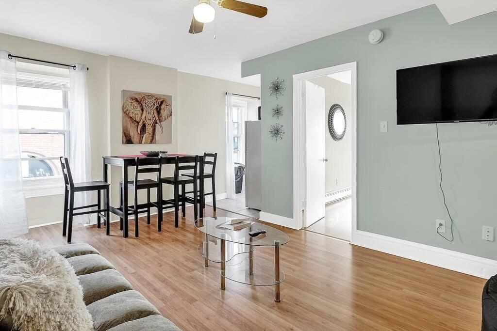 ein Wohnzimmer mit einem Sofa und einem Tisch in der Unterkunft Next To Penn Med & Center City Stylish 1bdrm Flat in Philadelphia