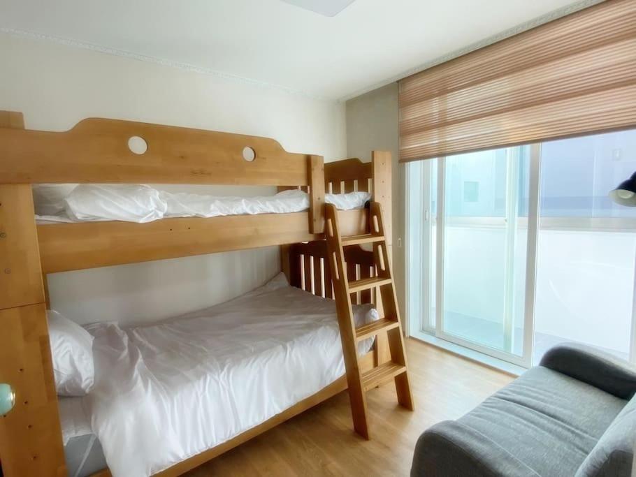 a bunk bed room with two bunk beds and a ladder at Sarangchae Yeonsu 2 in Incheon