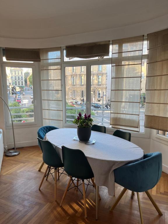 a dining room with a table and chairs and windows at Coeur de Marseille in Marseille