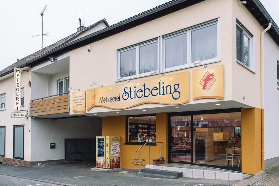 una tienda con un cartel en un lado de un edificio en Metzgerei Stiebeling - Stolberger Hof, 
