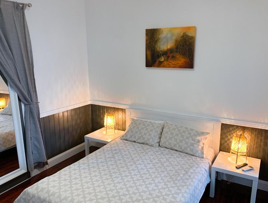 a bedroom with a bed and two tables with lamps at West End Studio 3 in Brisbane