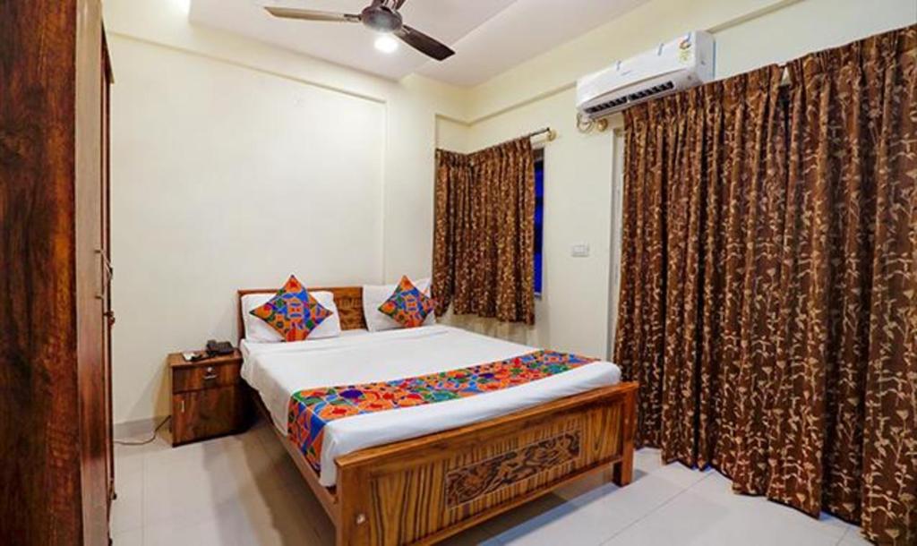 um quarto com uma cama e uma janela com cortinas em FabHotel Kings Inn And Suites em Bangalore