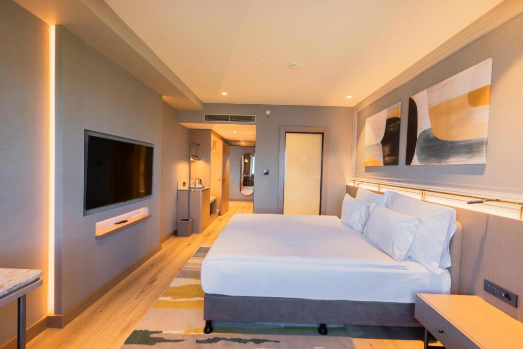 恰納卡萊的住宿－Kolin Hotel Spa & Convention Center，卧室配有一张白色大床和一台平面电视。