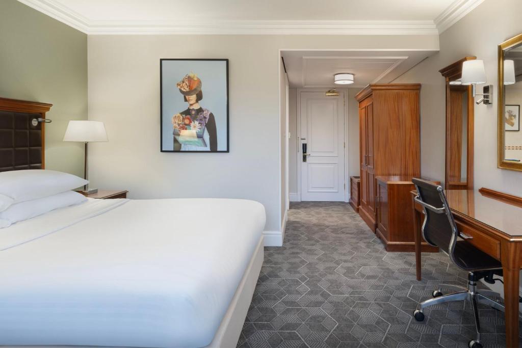 ハンティンドンにあるDelta Hotels by Marriott Huntingdonのベッドとデスクが備わるホテルルームです。