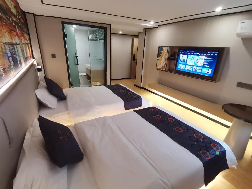1 Schlafzimmer mit 2 Betten und einem Flachbild-TV in der Unterkunft Yimimi Apartment - Guangzhou 13th Line Yide Road Metro Station in Guangzhou