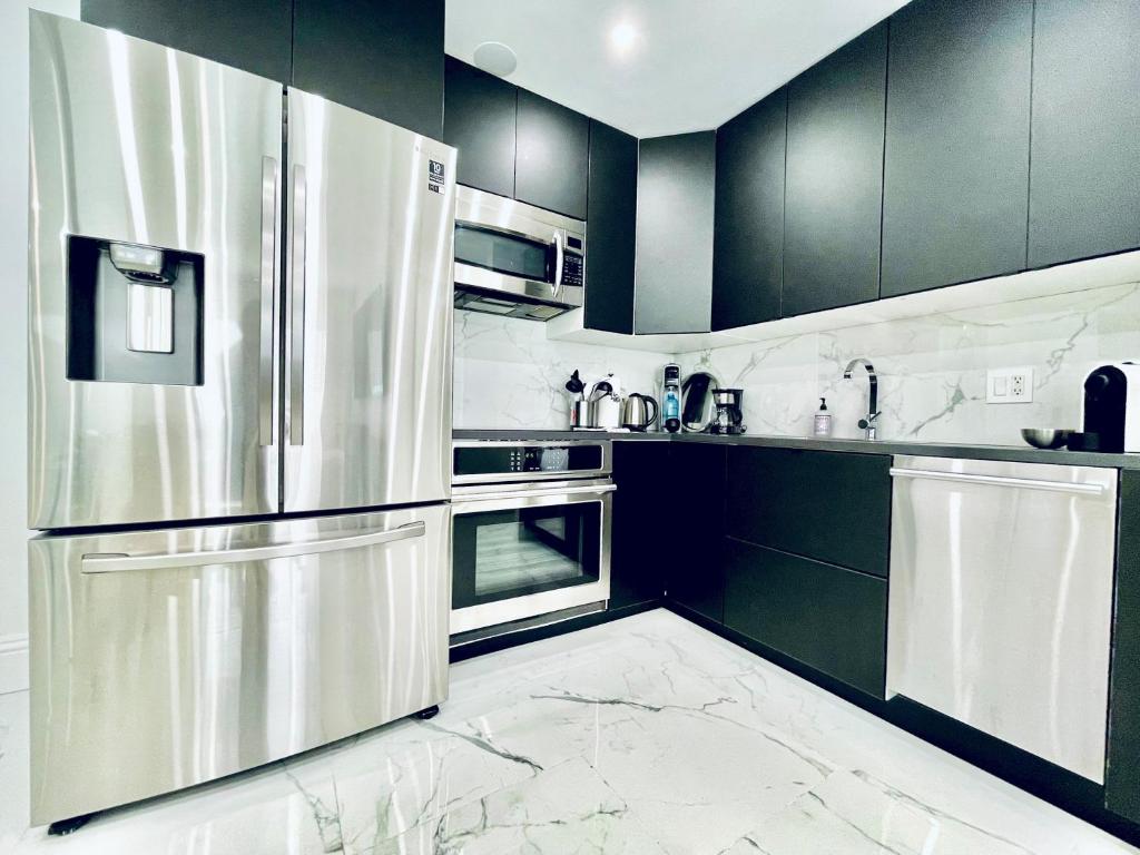 a kitchen with black cabinets and a stainless steel refrigerator at 2 room DisneyResortVillas by AmericanVacationLiving in Orlando