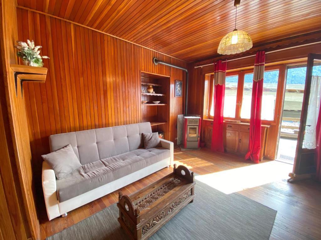 a living room with a couch in a room with wooden walls at Lignod - Appartamento con 2 Camere da Letto in Champoluc