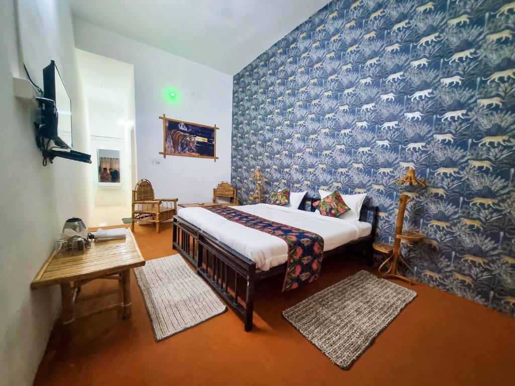 a bedroom with a bed and a blue wall at Saalwood Safari Lodge in Dhanwār