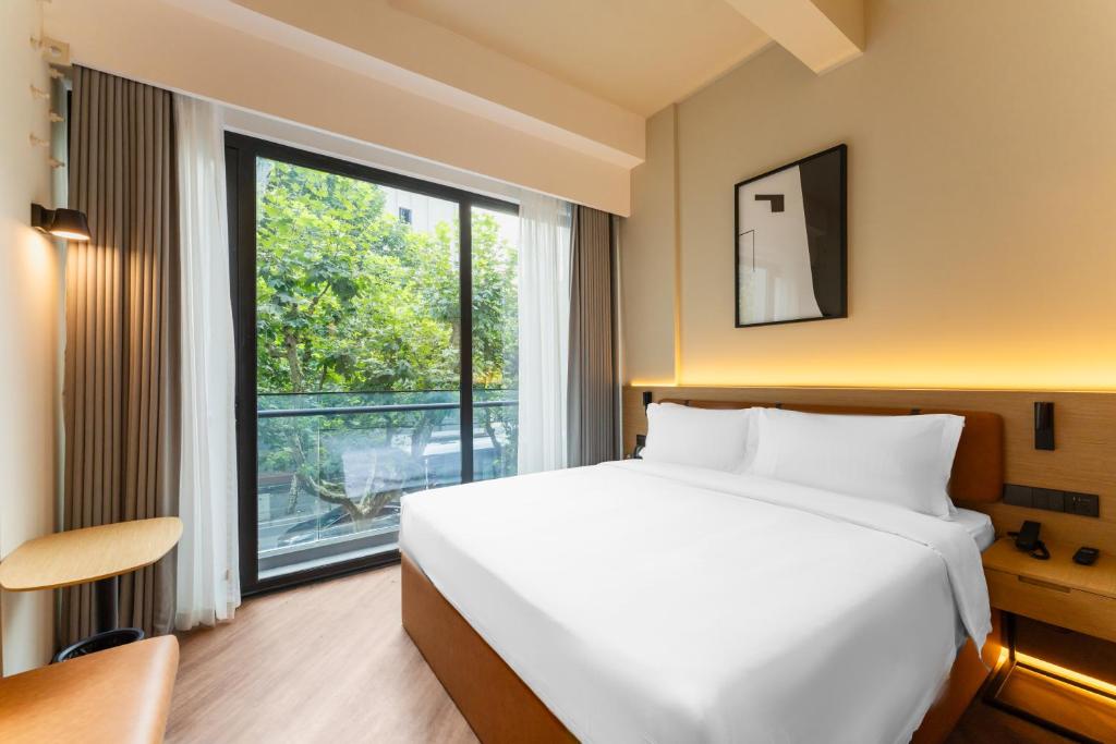 Postel nebo postele na pokoji v ubytování Mia Hotel - Shanghai Xuhui Jiaotong University
