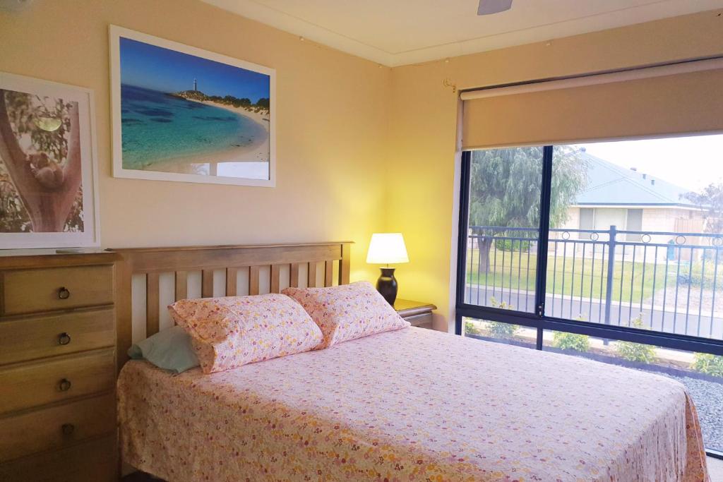 a bedroom with a bed and a view of the ocean at Dalyellup Private Guest House unit in Bunbury