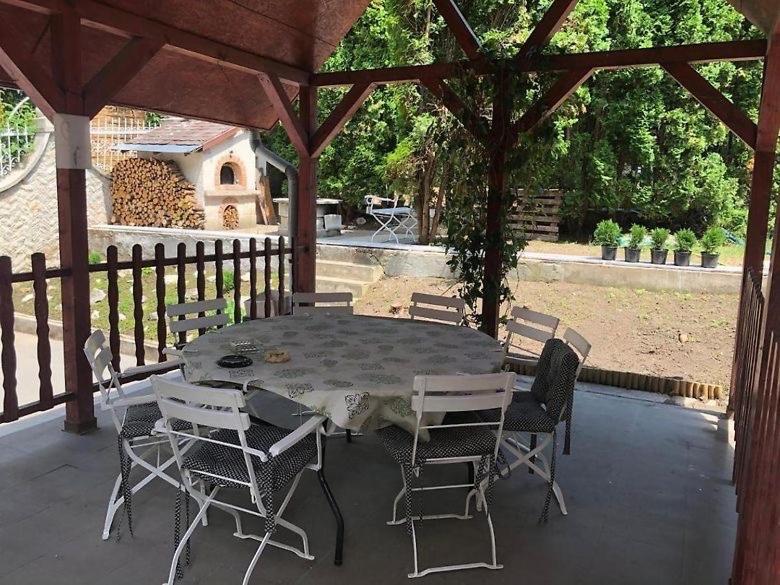 a table and chairs sitting under a gazebo at Omega Vendégház in Miskolc