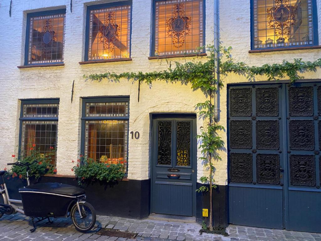 un edificio con una bicicleta estacionada frente a él en Huyze Peerdenbrugghe en Bruges