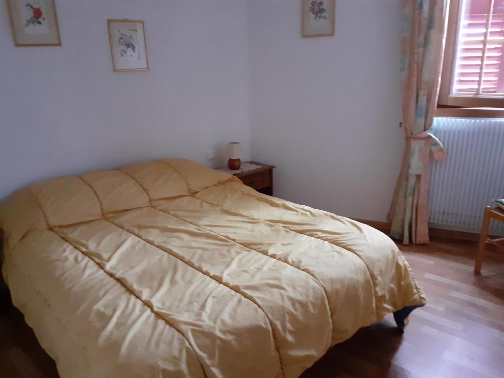 Una cama en un dormitorio con una manta. en LES VIGNERONS en Niedermorschwihr