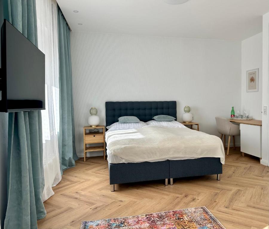 Schlafzimmer mit einem Bett, einem Schreibtisch und einem TV in der Unterkunft morand I Apartments in Salzburg