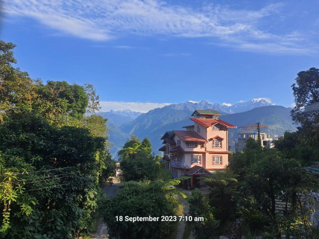 a house on a hill with mountains in the background at Ifseen Villa in Pelling