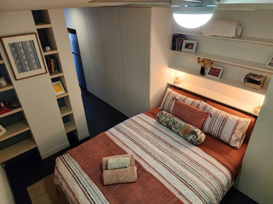 Dormitorio pequeño con cama con almohada en Boutique City Apartment with Iconic Mountain Views en Canberra