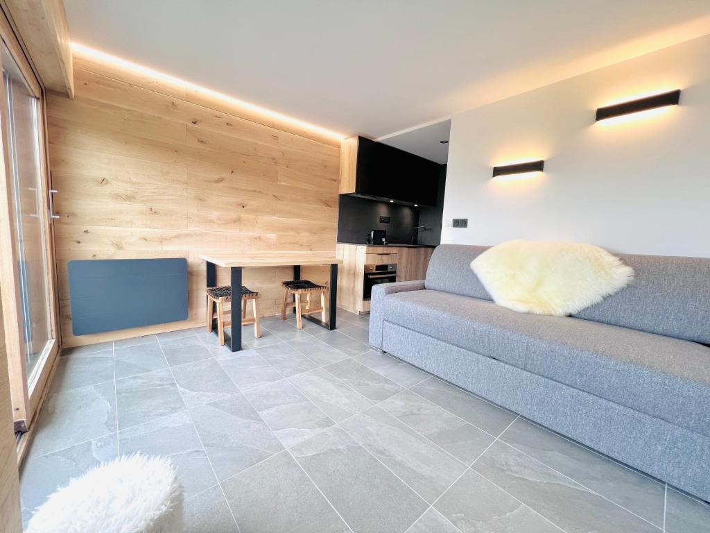 a living room with a couch and a table at Appartement 4 personnes pistes in Combloux