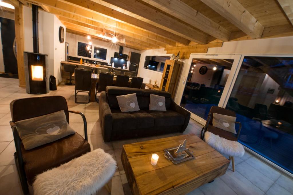 uma sala de estar com um sofá e uma mesa em Chalet proche des pistes de ski avec vue et spa em Gérardmer