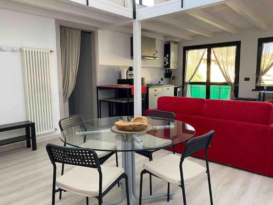 a living room with a glass table and a red couch at MyLoft Apartment in Budrio