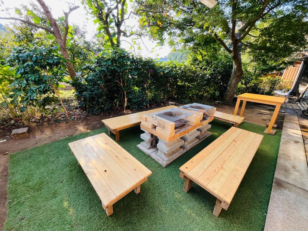 千葉的住宿－Izakaya inn "Tsubaki" - Vacation STAY 14130，草地上的野餐桌和长椅